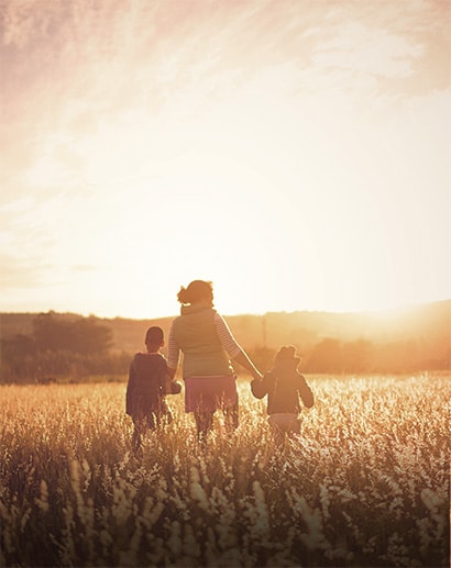 Mother and children walking across field - calming image.